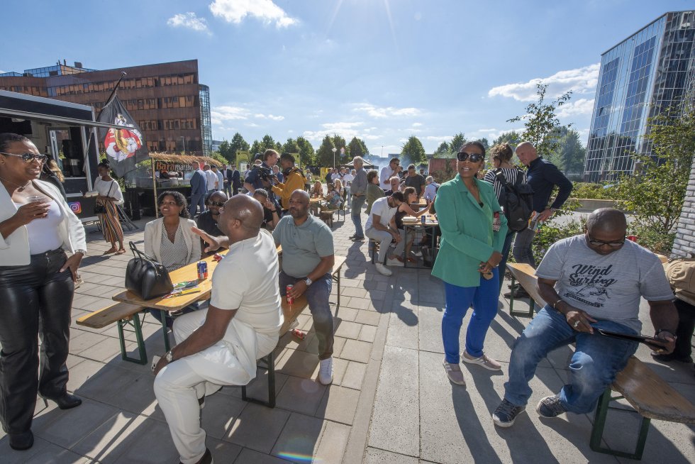 Een terras vol met mensen, die in gesprek zijn met elkaar, op een zonnige dag