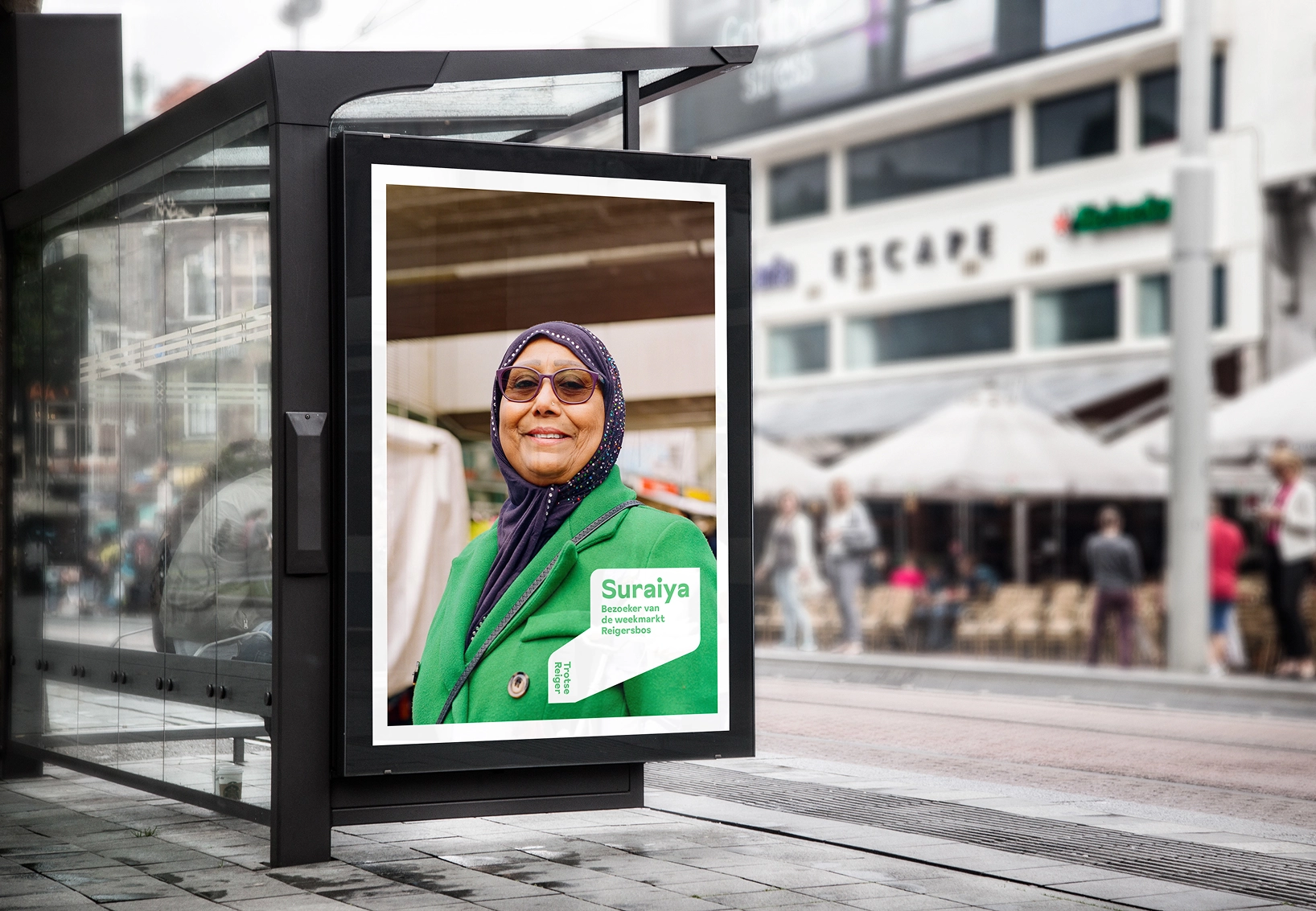 Een poster van een vrouw in een abri bij een bushalte